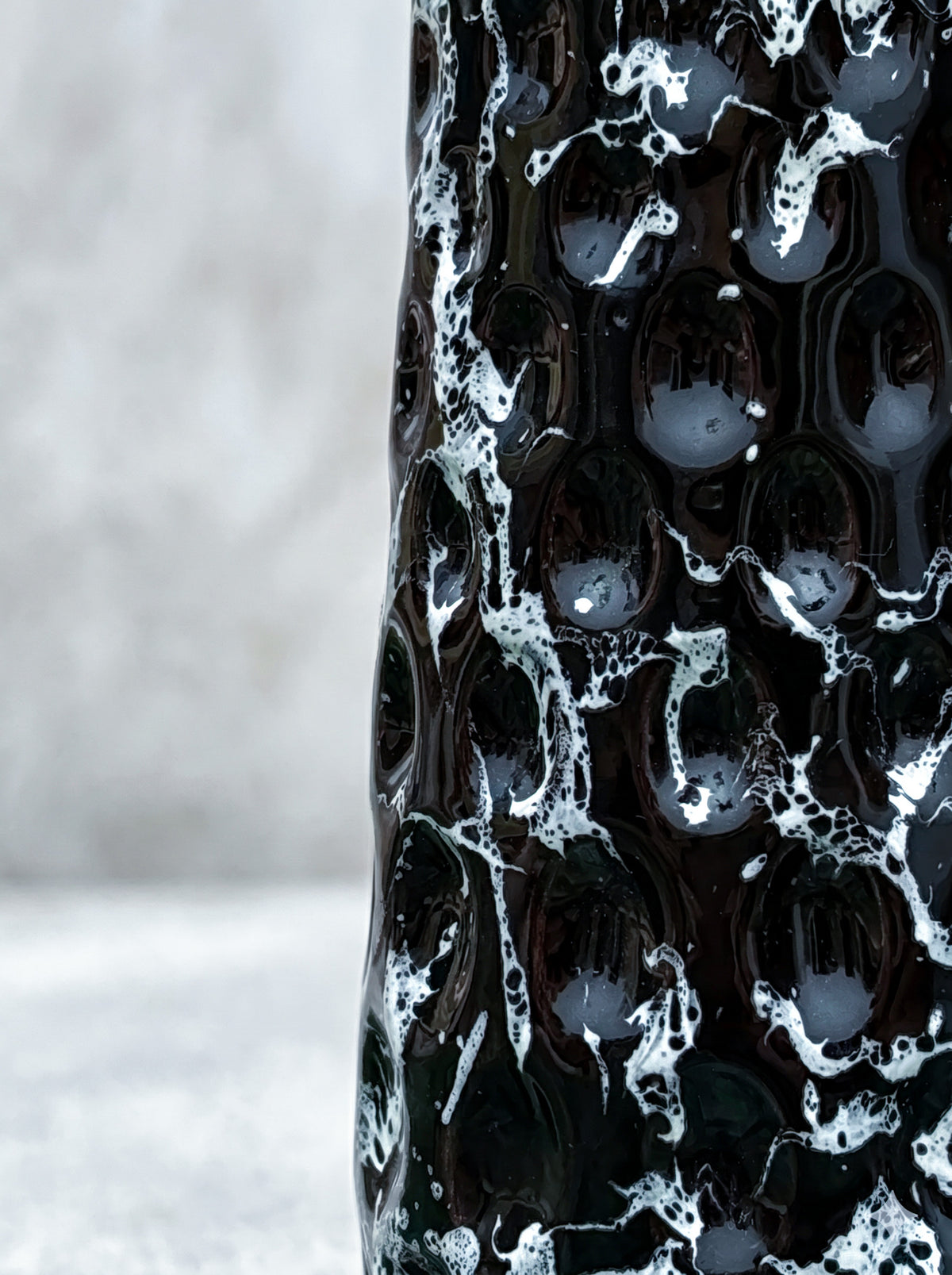 Dark Fumo black and white veined glass vase styled on a shelf